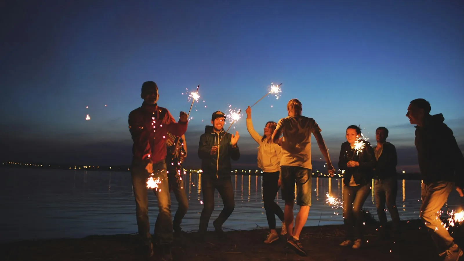Friends celebrating with sparklers at night