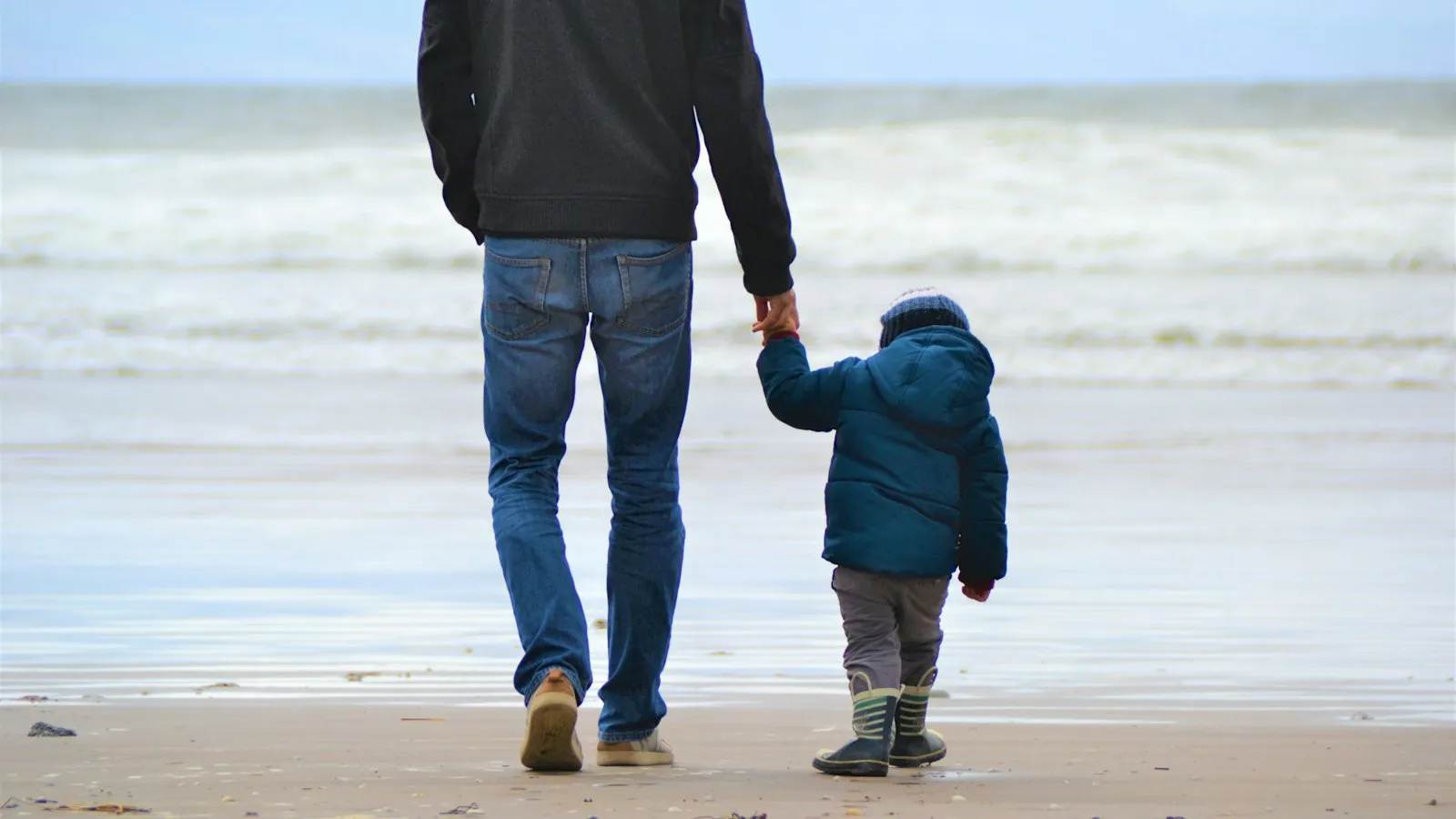 A father and son walking along the shore