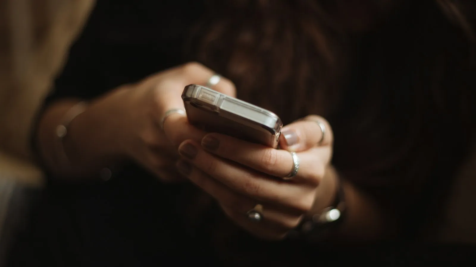 Hands typing on a smartphone