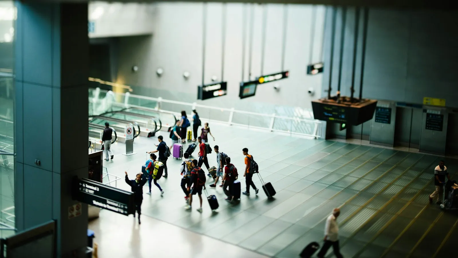 Travelers with luggage walking through an airport