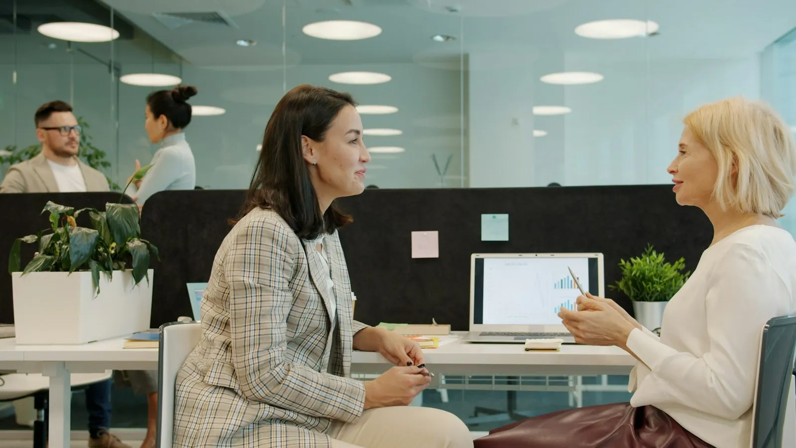 Two coworkers talking at a desk