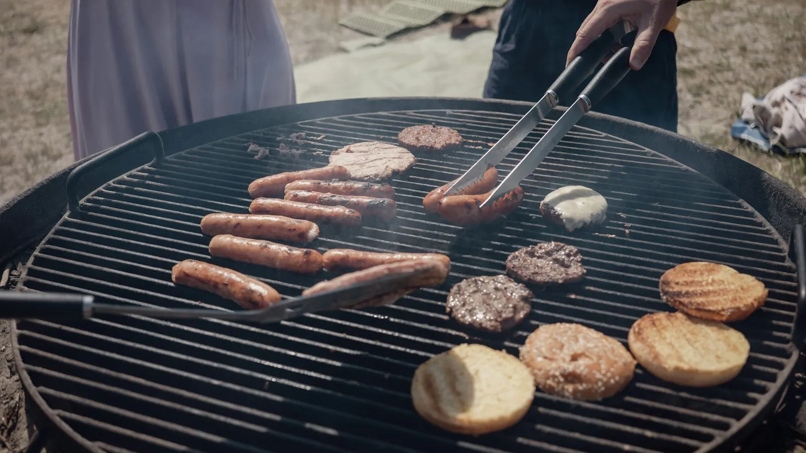 Burgers and sausages on an outdoor grill