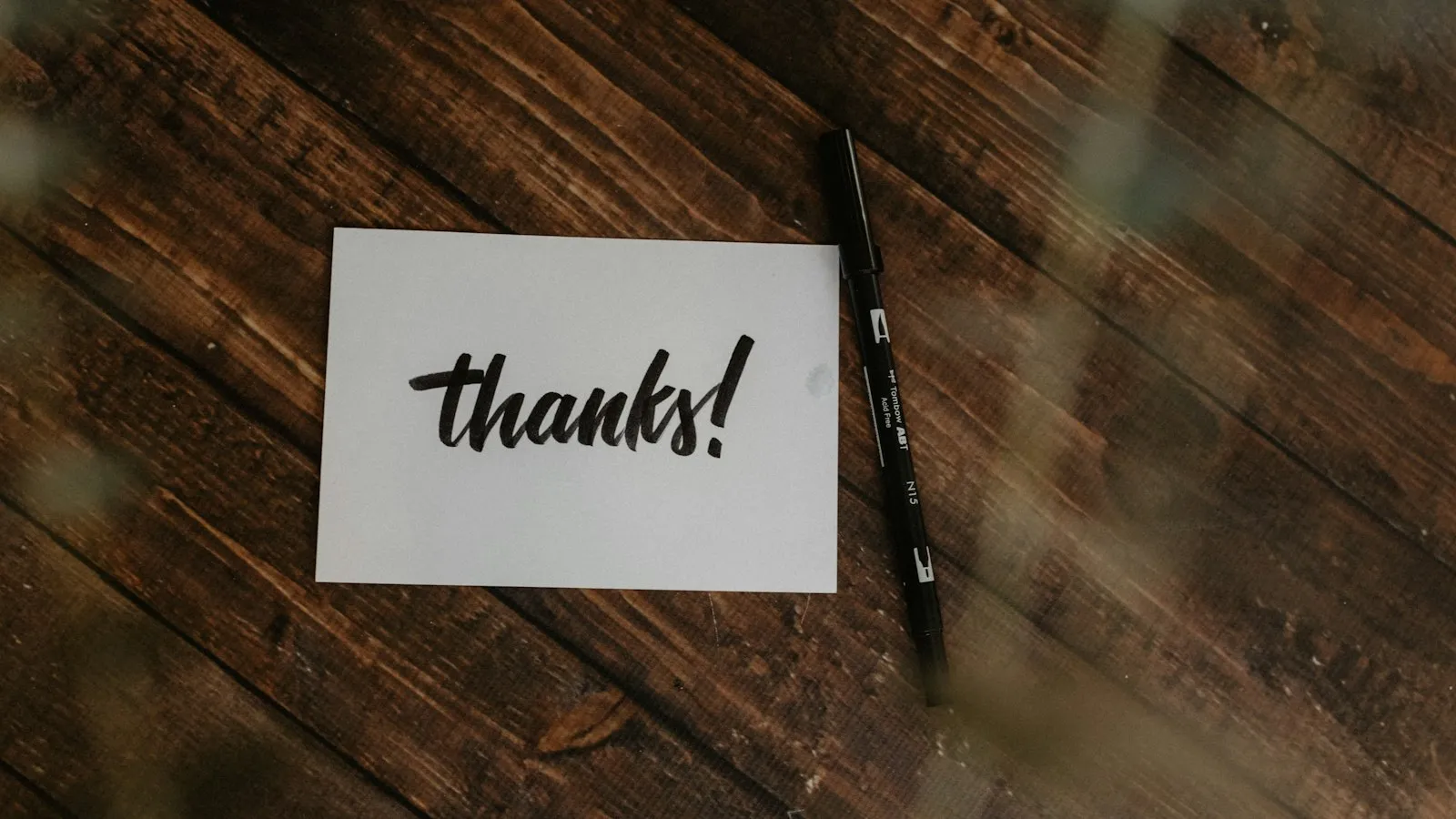 A handwritten thank-you note and a pen
