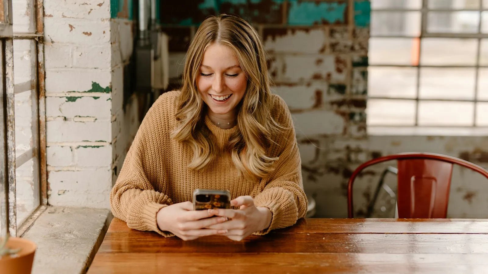 A woman at a table looking at her phone