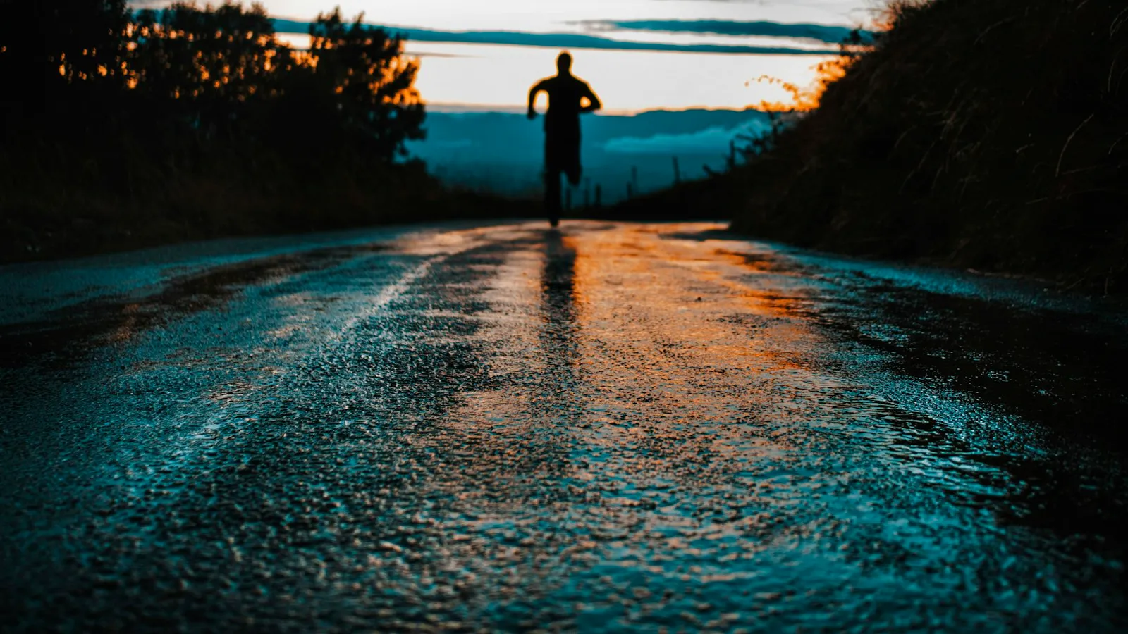 A runner silhouetted on an open road