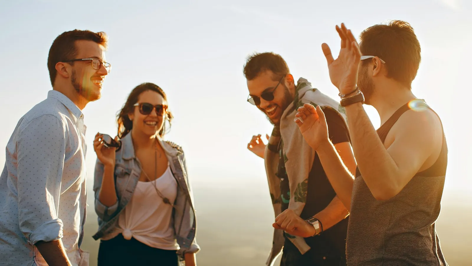 Four friends laughing together outside