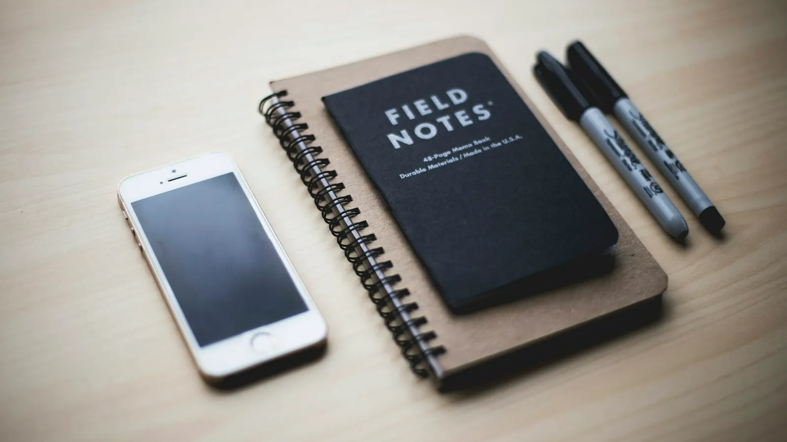 A phone next to a small notebook