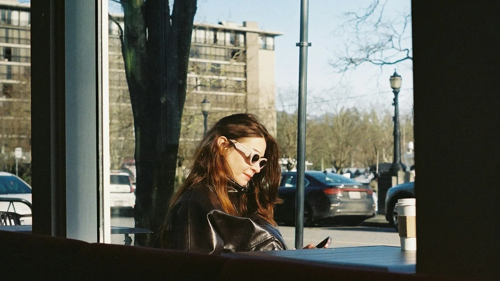A woman looking at her phone inside a café