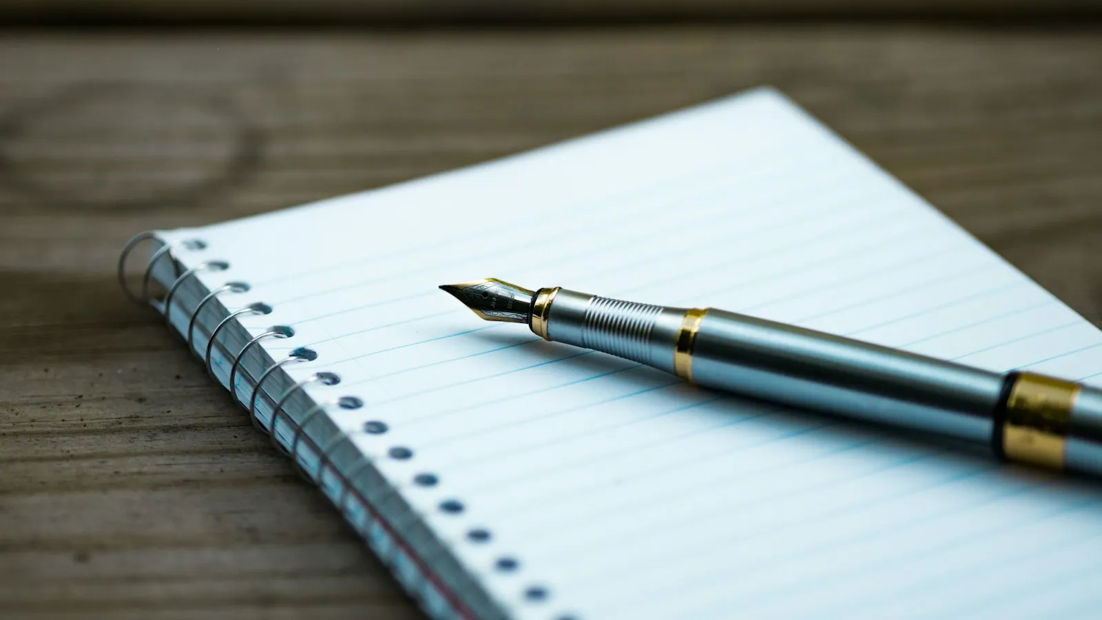 A fountain pen resting on a notebook